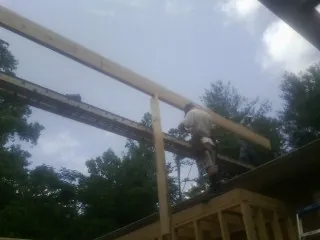 Carpenter setting a ridge beam over a new addition frame — Ice Dam Removal by Roofing Brothers in Southgate