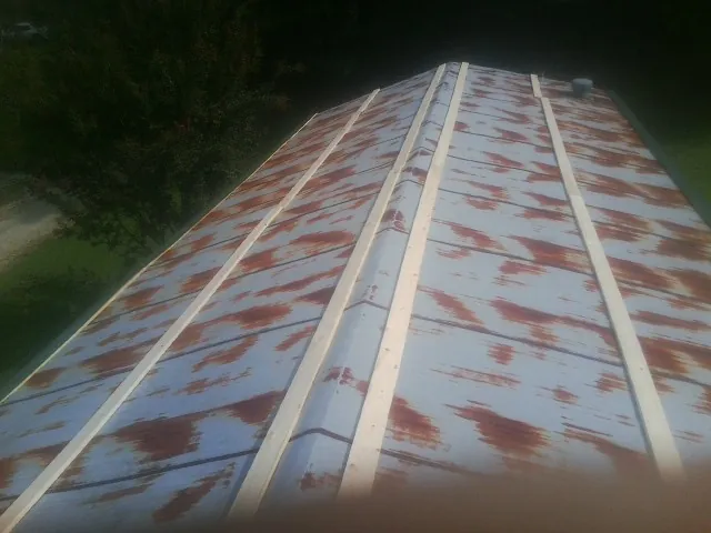 Rusted metal roof panels with new wood purlins before replacement — Storm Damage Roof Repair in Southgate by Roofing Brothers