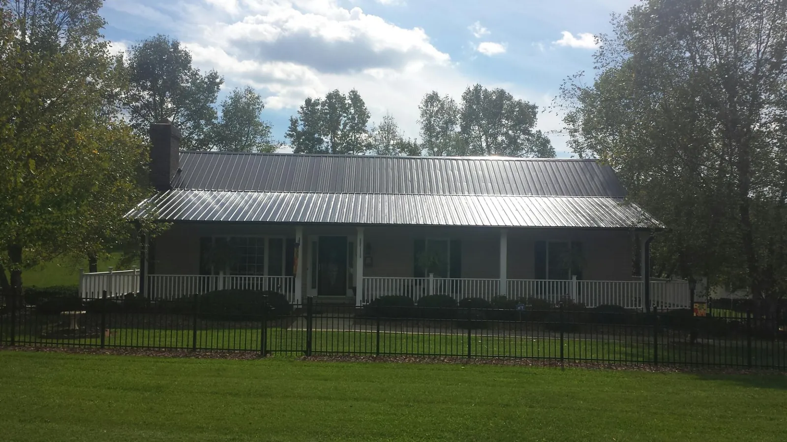 Gray metal roof on a brick ranch with a full width front porch — Gutter Guard Installation work by our crew in Southgate