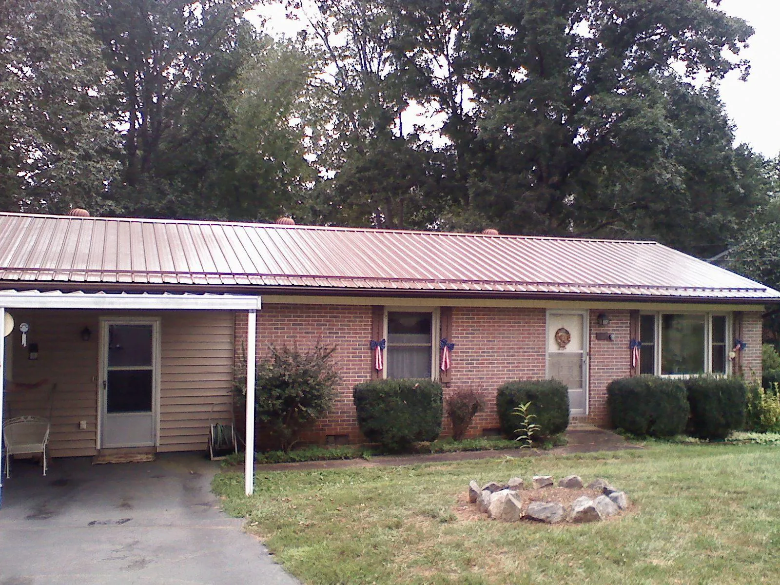 Bronze metal roof and carport on a brick ranch home — Roof Repair work by our crew in Southgate
